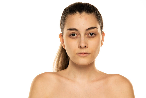retrato de una joven mujer sin camisa sin maquillaje sobre un fondo blanco - Foto, imagen