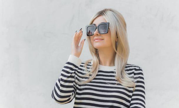  60s-70s look. Woman blonde hair vintage makeup wear striped jumper, fashionable concept - 写真・画像
