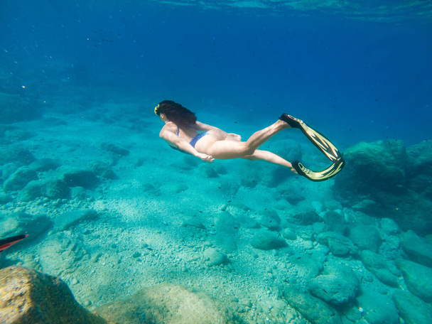 όμορφη γυναίκα κολύμπι κάτω από το νερό με μάσκα ψαροντούφεκο και πτερύγια αντίγραφο χώρο - Φωτογραφία, εικόνα