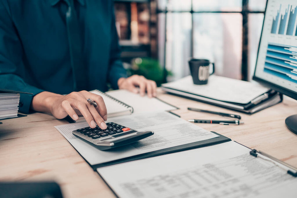 Investors working on desk office and using a calculator to calculate balance, projit, currency and cost. Accounting and  Financial concept. - 写真・画像
