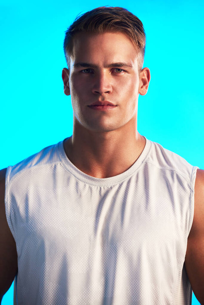 Its all about the will to win. Studio portrait of a handsome young male athlete posing against a blue background. - Foto, imagen
