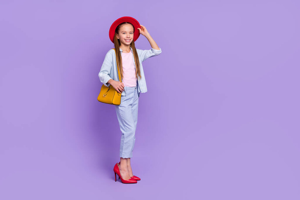 Photo of shiny adorable little school girl wear denim shirt walking mother shoes empty space isolated purple color background - Zdjęcie, obraz
