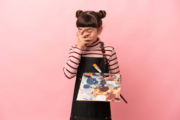 Маленька дівчинка-художник тримає палітру ізольовано на рожевому фоні сміється
 - Фото, зображення