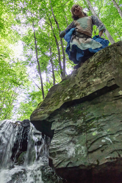 brünette Frau steht auf einem Stein im Wald, Sommer, ukrainische Karpaten - Foto, Bild