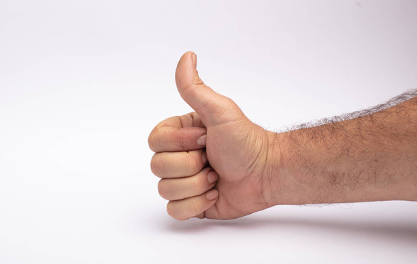 man's hand makes ok gesture, white background - 写真・画像