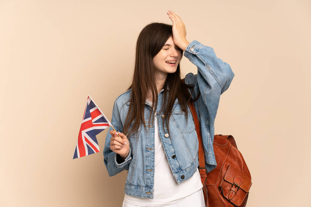 Young Ukrainian girl holding an United Kingdom flag isolated on beige background has realized something and intending the solution - 写真・画像