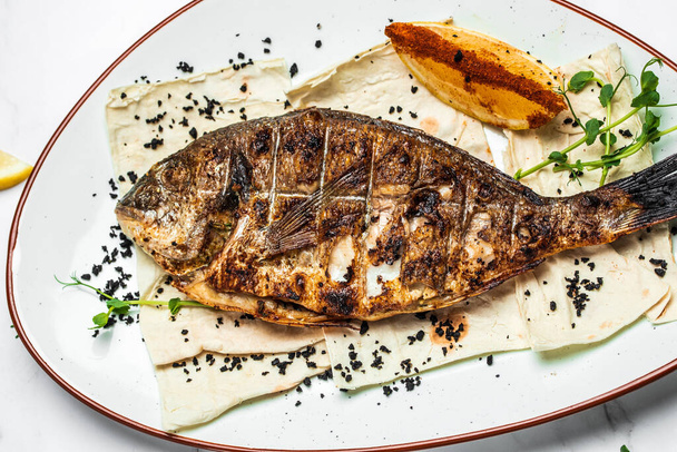 Plate with prepared dorado fish, Whole Bbq sea bream baked. Dorado grill. Ketogenic, keto or paleo diet lunch, Healthy food trend. Top view, - Fotoğraf, Görsel