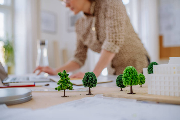 Close-up of woman architect with model of houses in office - Foto, Bild