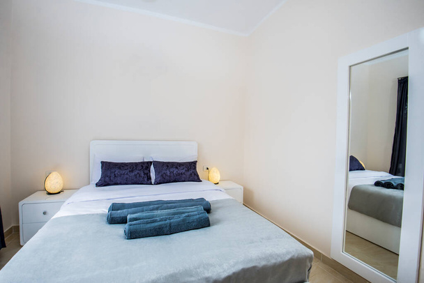 Εσωτερική διακόσμηση διακόσμηση επίπλωση πολυτελούς show home bedroom που δείχνει έπιπλα και διπλό κρεβάτι στο θέρετρο με καθρέφτη στον τοίχο - Φωτογραφία, εικόνα