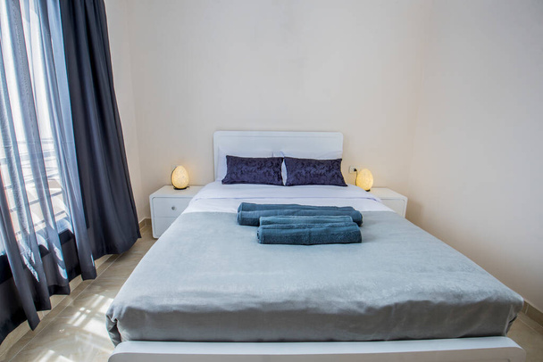 Interieur inrichting inrichting van luxe show home slaapkamer met meubilair en een tweepersoonsbed in resort met raam - Foto, afbeelding