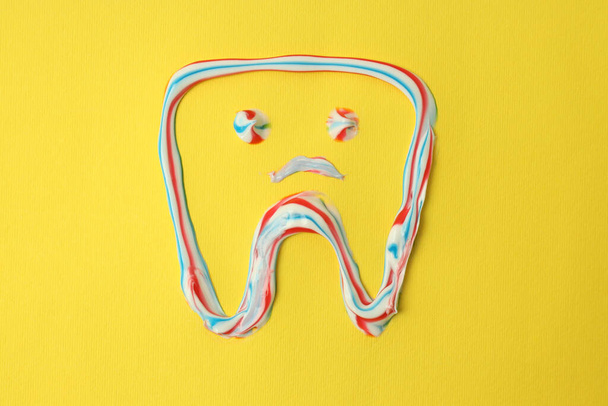 Δόντι με οδοντόκρεμα σε κίτρινο φόντο - Φωτογραφία, εικόνα
