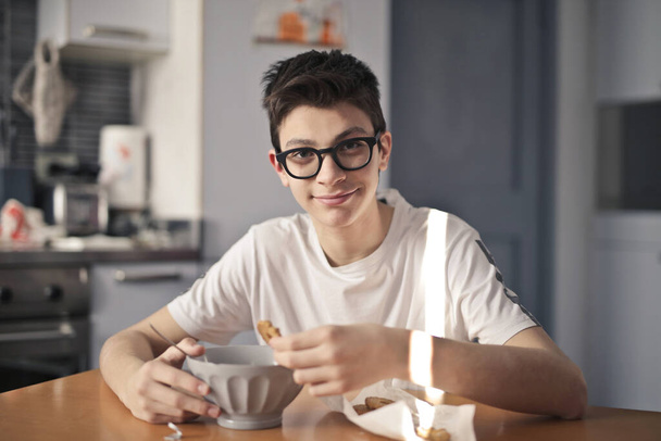 young boy has breakfast with milk and cookies - Fotó, kép