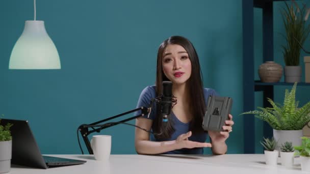 Punto di vista di donna asiatica che fa recensione del prodotto con batteria v mount - Filmati, video