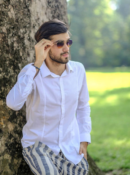 handsome Italian dark-haired guy with white shirt and sunglasses outdoors. High quality photo - Photo, Image