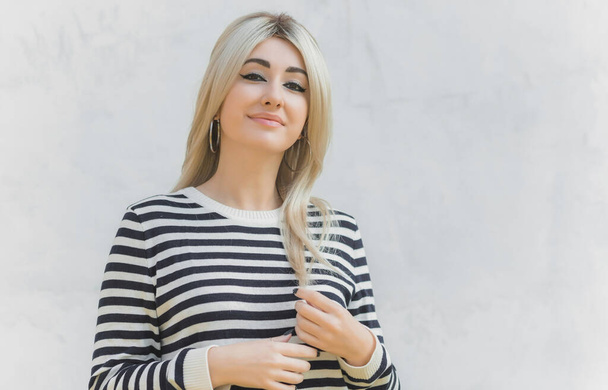 60s-70s look. Woman blonde hair vintage makeup wear striped jumper, fashionable concept - 写真・画像