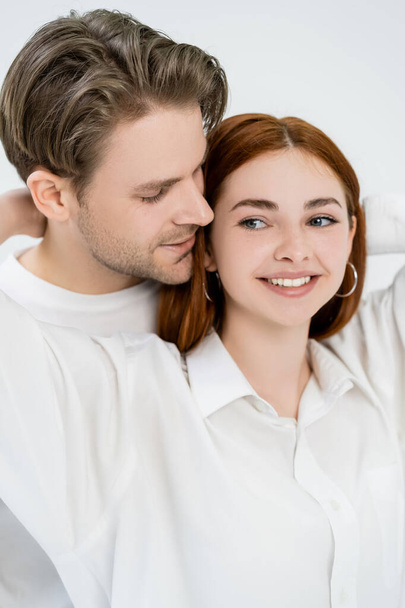 Young man standing near red haired girlfriend isolated on white  - Φωτογραφία, εικόνα