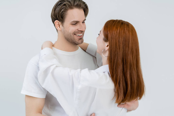 Jovem ruiva mulher abraçando namorado isolado no branco  - Foto, Imagem