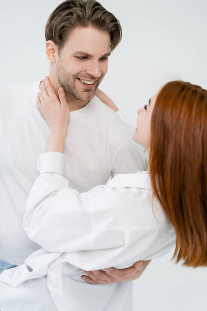 Blurred woman touching smiling boyfriend isolated on white  - Фото, зображення