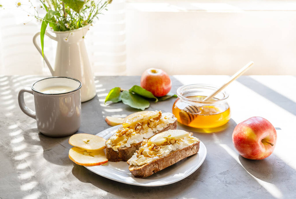 Kawałki chleba z serem wiejskim, miodem, jabłkami i orzechami. Koncepcja śniadania - Zdjęcie, obraz