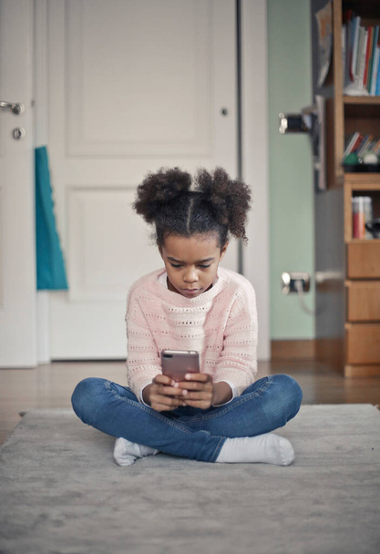 little girl uses a smartphone at home - Φωτογραφία, εικόνα