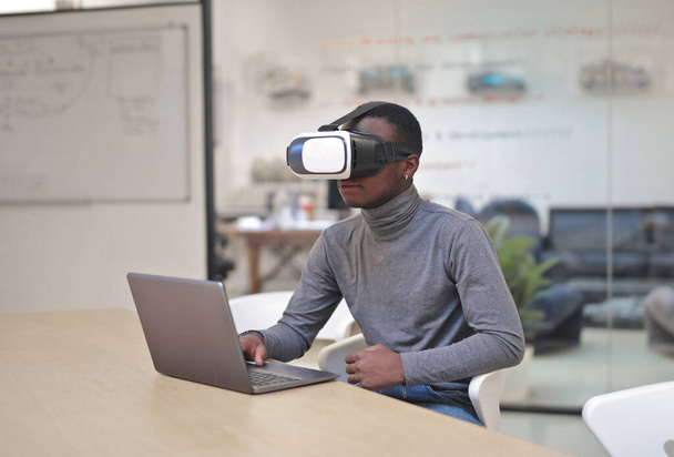 young man in an office with a virtual mask and a computer - Photo, Image