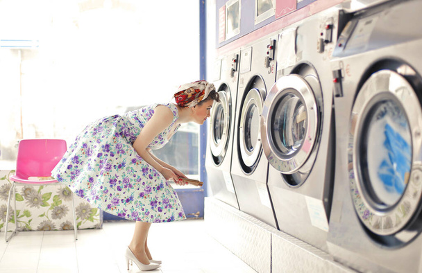 young woman in a room of public washing machines - Fotoğraf, Görsel