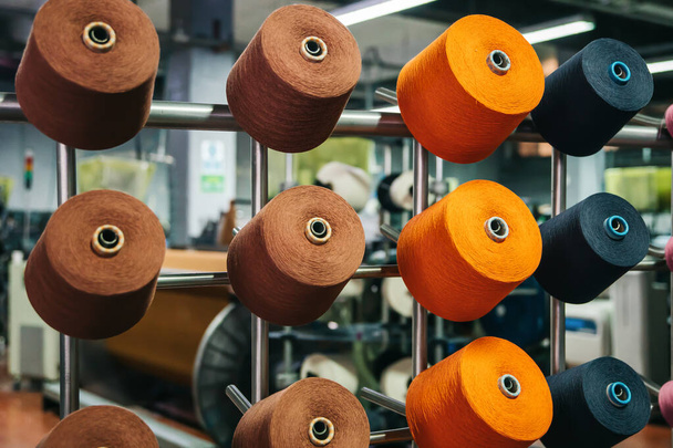 Colorful cotton yarns or threads on spool tube bobbins at cotton yarn factory - Photo, Image