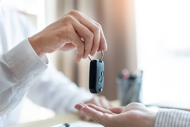 Insurance concept the customer receiving the car key after finishing the contract of car purchasing. - Photo, Image