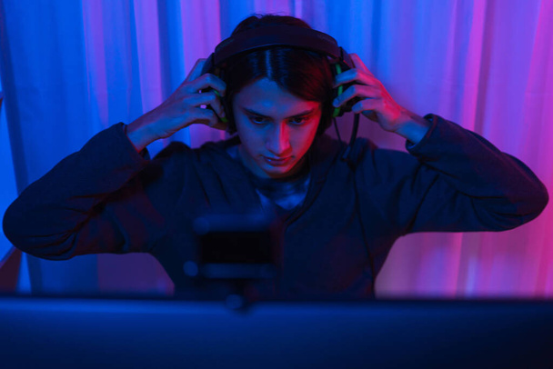 Conceito de fluxo de jogo, Streamer masculino usar headset para assistir torneio de jogos on-line em transmissão ao vivo. - Foto, Imagem