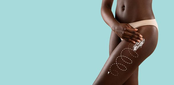 slanke afrikaanse amerikaanse vrouw in ondergoed aanbrengen lotion op heupen - Foto, afbeelding