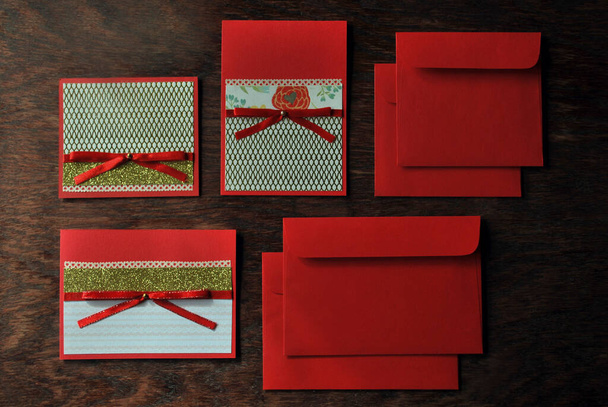 Red postcards and envelopes on a wooden table made by hand. Flat lay, top view - Photo, Image