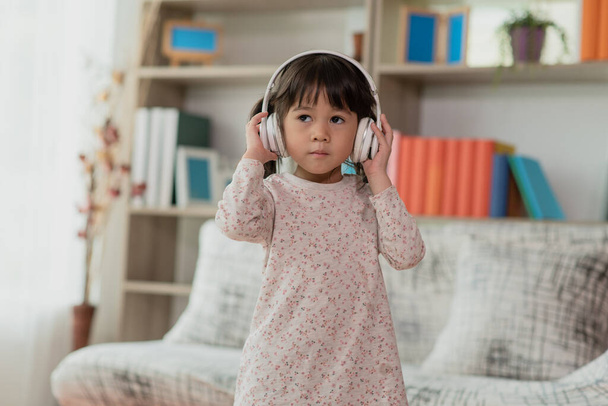 Portrait d'enfant asiatique heureux profiter d'écouter de la musique avec des écouteurs - Photo, image