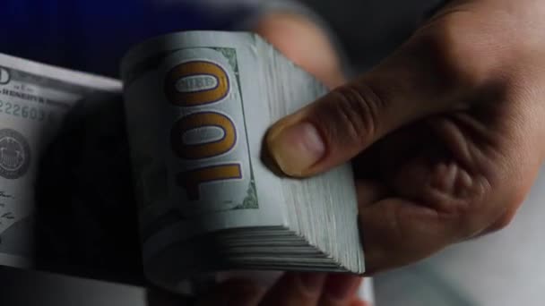Mãos contando notas de dólares americanos ou pagando em dinheiro contra o pano de fundo das luzes do carro da polícia - Filmagem, Vídeo
