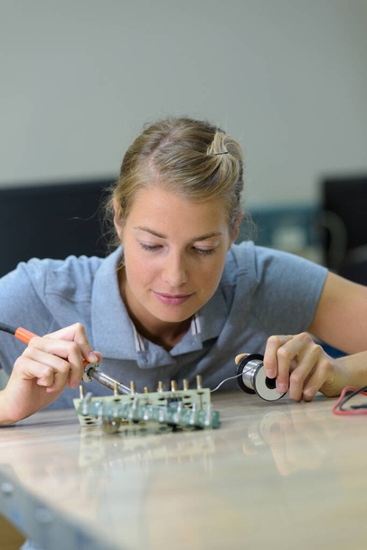 female electrical engineering student soldering circuit - Fotó, kép