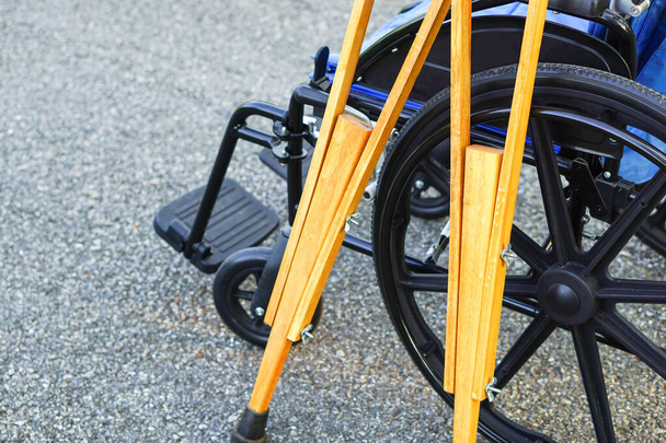The crutches lean against the wheelchair in open spaces or outdoor. Healthcare and medical concept. - Fotoğraf, Görsel