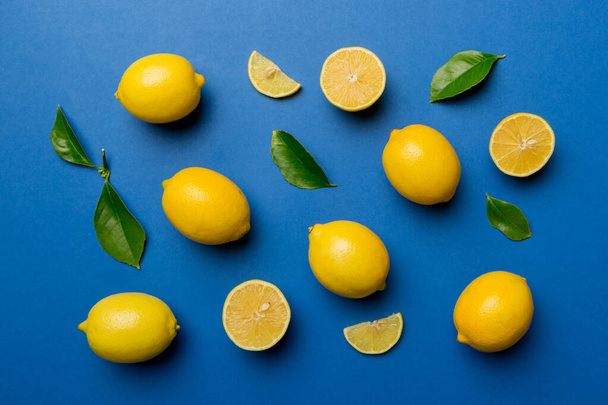 Many fresh ripe lemons as colored background, top view. Elegant background of lemon and lemon slices Top view flat lay. - Valokuva, kuva