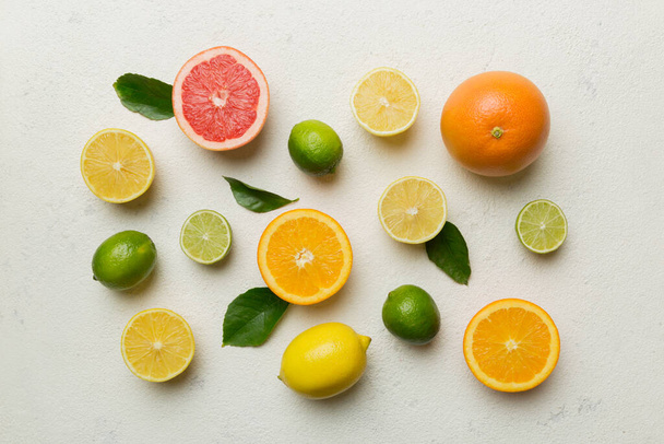 Flat lay of citrus fruits like lime, orange and lemon with lemon tree leaves on light colored background. Space for text healthy concept. Top view. - Foto, Imagem