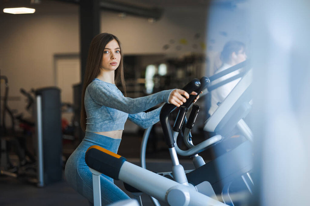 Fitness girl fazendo treinamento cardio no ginásio no simulador orbitrek - Foto, Imagem