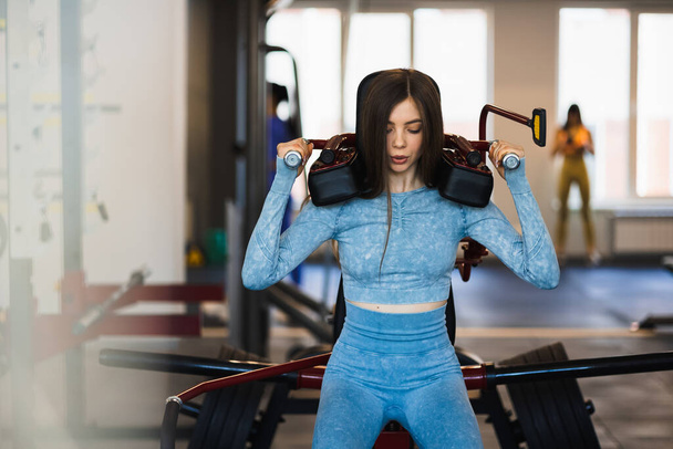 アスレチック女性はトレーニングマシンで不法占拠を行う。脚の筋肉運動 - 写真・画像