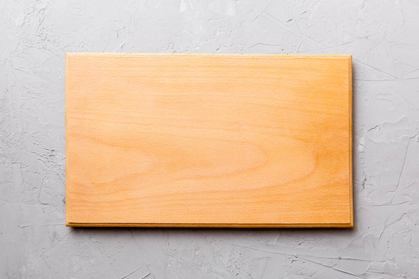 Top view of wooden cutting board on cement background. Empty space for your design. - Photo, Image