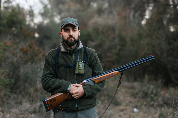 Sebevědomý muž s puškou v lese při lovu - Fotografie, Obrázek