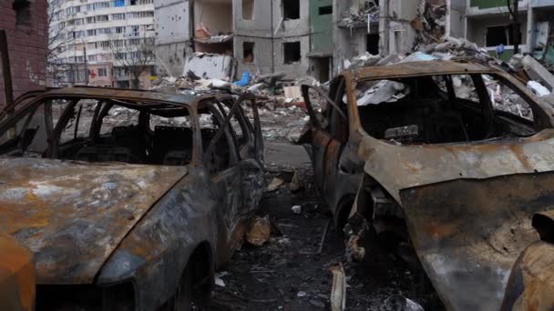 Tsjernihiv Oekraïne 2022: Burnt vernietigde burgerauto 's tegen de achtergrond van verwoest gebouw als gevolg van een luchtaanval. Resultaat van raket of artillerie beschietingen door het Russische leger. Oorlog - Video