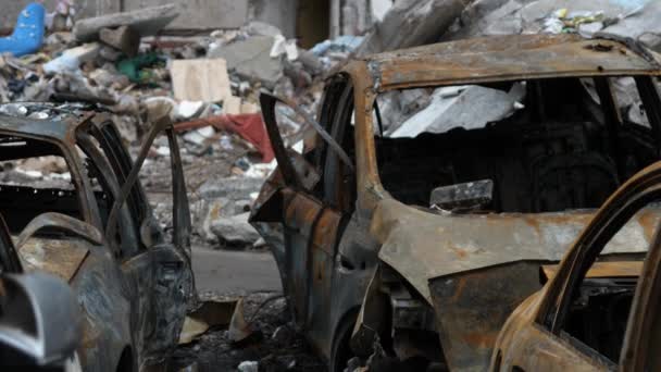Tchernihiv Ukraine 2022 : brûlé détruit des voitures civiles sur fond de bâtiment détruit à la suite d'une attaque aérienne. Résultat d'un bombardement de roquettes ou d'artillerie par l'armée de la Fédération de Russie. Guerre - Séquence, vidéo