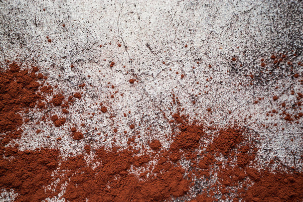 natural cocoa powder for chocolate and drinks scattered on a gray neutral concrete background. Texture for advertising and design - Fotó, kép