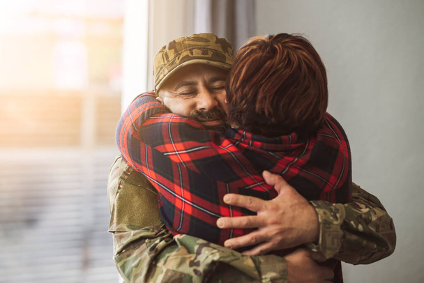 Η γυναίκα αγκαλιάζει τον στρατιωτικό της σύζυγο. - έννοια του πολέμου - - Φωτογραφία, εικόνα