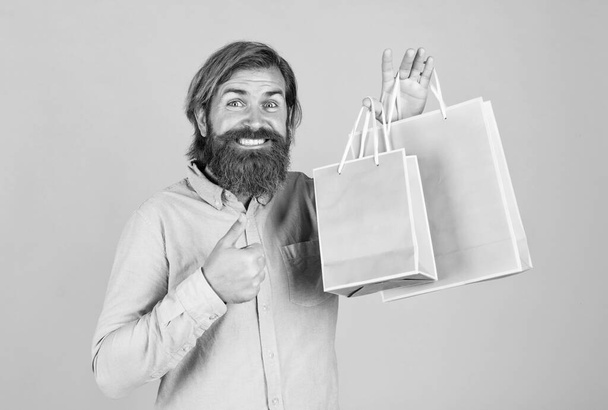 look over there. successful shopaholic. bearded man ready for holiday. sale and discount. hipster with beard hold present pack. brutal caucasian hipster with gift. male go shopping with purchase - Foto, immagini