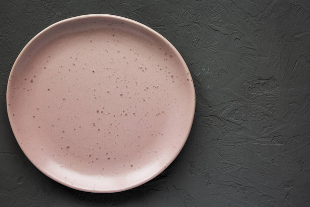 Placa de cerámica rosa vacía sobre un fondo gris, vista superior. Acostado plano, arriba, desde arriba. Copiar espacio. - Foto, Imagen