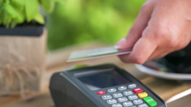 NFC luottokorttimaksu. Nainen maksaa kontaktittomalla luottokortilla NFC-teknologialla. Langaton rahansiirto. Langaton maksu - Materiaali, video