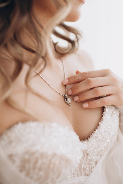 νύφη με νυφικό αγγίζει απαλά το δαχτυλίδι με τα δάχτυλά της - Φωτογραφία, εικόνα