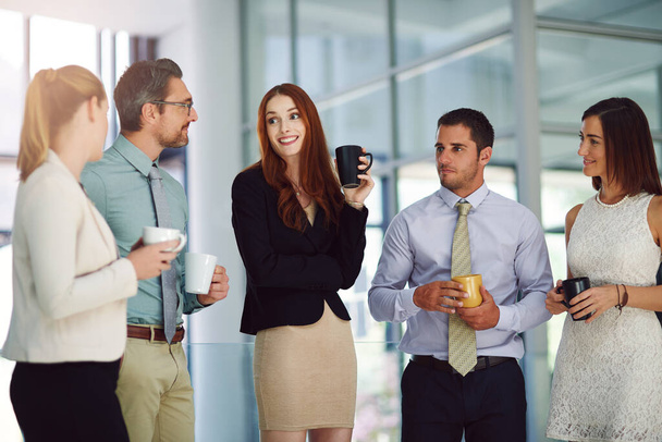 Kaffee erleichtert immer wichtige Diskussionen. Aufnahme von Kollegen beim Gespräch und Kaffeetrinken in einem modernen Büro. - Foto, Bild